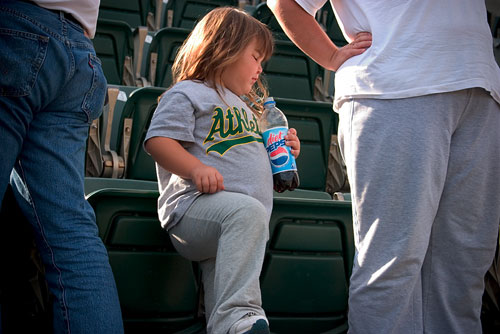 A chubby little girl clutching a bottle of Diet Pepsi